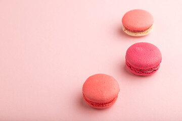 Magenta and pink macaroons on pink pastel background.  side view, copy space.