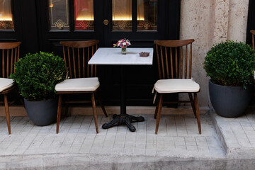 Tables and chairs standing outside near cafeteria on a summer day