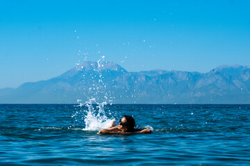 child in the sea splashing water 