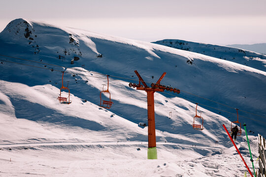 Panoramic view over the ski slope Poiana Brasov ski resort in Transylvania, Pine forest covered in snow on winter season,Mountain landscape in winter with the Bucegi Mountains in the background.