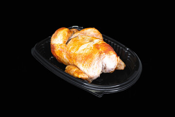 Roasted whole chicken in a black package