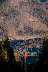 Panoramic view over the ski slope Poiana Brasov ski resort in Transylvania, Pine forest covered in snow on winter season,Mountain landscape in winter with the Bucegi Mountains in the background.
