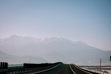 Panoramic view over the ski slope Poiana Brasov ski resort in Transylvania, Pine forest covered in snow on winter season,Mountain landscape in winter with the Bucegi Mountains in the background.