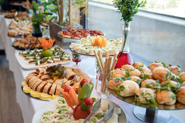 Banquet table with snacks, food on plates, festive table, corporate food