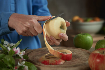 Crop woman peeling apple in kitchen