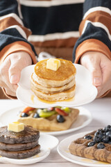 Pancake with butter and honey maple syrup set on white cafe table.