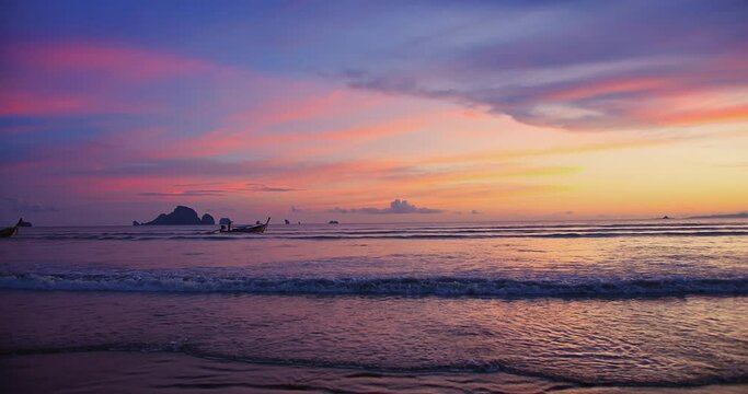 Beautiful amazing sunset over tropical ocean Andaman sea beach with colorful sky and Long tail boats in summer at Ao Nang, Krabi, Thailand, tourism vacation holiday travel trip destination concept