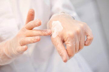 beautician in gloves shows the texture of the cream