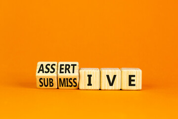 Submissive or assertive symbol. Concept words Submissive and assertive on wooden cubes. Beautiful...