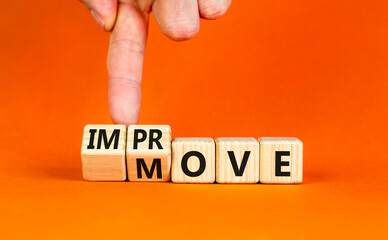 Move and improve symbol. Concept words Move and Improve on wooden cubes. Businessman hand. Beautiful orange table orange background. Business Move and Improve concept. Copy space.
