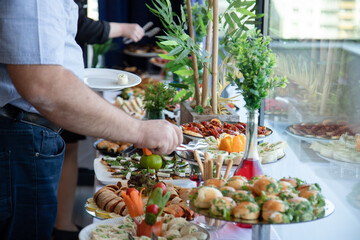 Banquet table with snacks, food on plates, festive table, corporate food