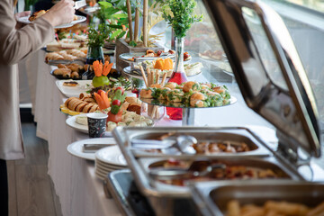 Banquet table with snacks, food on plates, festive table, corporate food