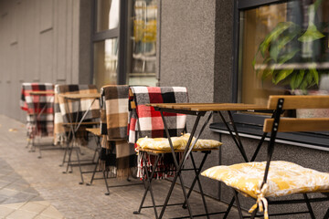 comfy seats in a street cafe with blankets
