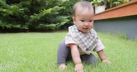 Portrait happiness little cute baby toddler sitting on green lawn and hand touching playing learning explore grass enjoy lifestyle at nature park garden home in summertime