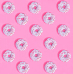 Donut with pink glaze on the pink background. Flat lay. Pattern.