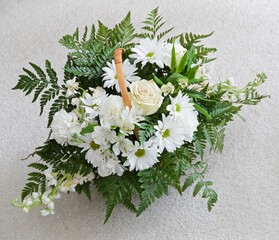 Beautiful floral arrangement with white flowers.  Gorgeous bouquet top-view with basket handle.