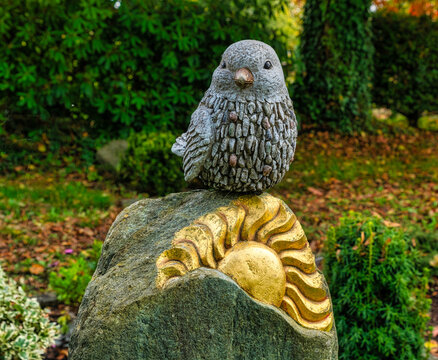 schöner Vogel auf einem Grabstein mit Sonnensymbol auf einem Friedhof in Wülfrath
