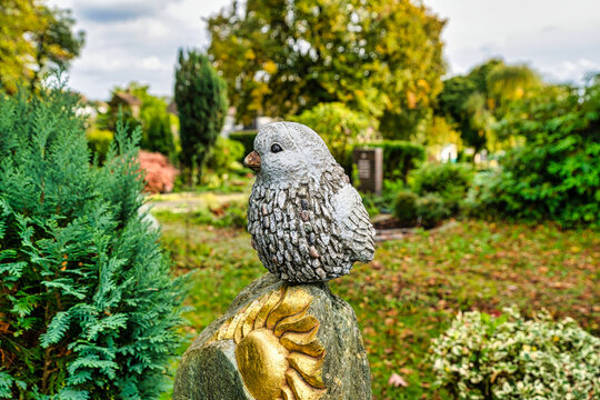 großer Vogel auf einem Grabstein mit Sonnensymbol auf einem Friedhof in Wülfrath