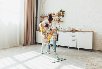 a little daughter and her mom clean the house, a child washes the kitchen floor, a cute little...