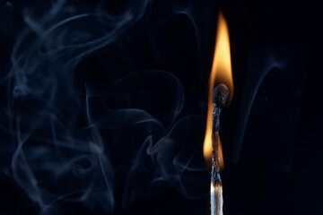 An image of a match stick flame in front of a black