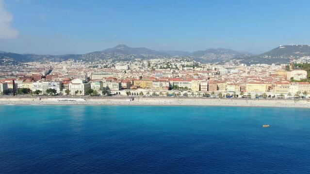 Beautiful panorama of English Promenade in Nice, France. Palm trees, old houses in Old Town Azure Sea And Green Hills. Summer in French Riviera. View from sky, Drone video 