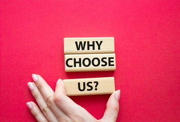 Why choose us symbol. Concept words Why choose us on wooden blocks. Beautiful red background. Businessman hand. Business and Why choose us concept. Copy space.