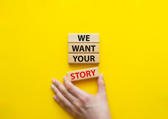 We want your story symbol. Concept words We want your story on wooden blocks. Beautiful yellow background. Businessman hand. Business and We want your story concept. Copy space.