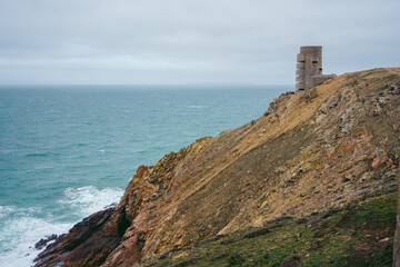 Abandoned World War II bunker on the cliffs of the island on cloudy day