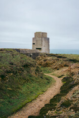 Fototapeta na wymiar Abandoned World War II bunker on the cliffs of the island on cloudy day