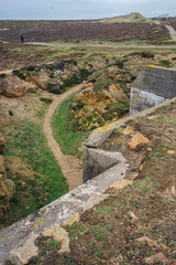 Abandoned World War II bunker on the cliffs of the island on cloudy day