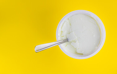 natural skyr yogurt in plastic cup with spoon isolated in color background 