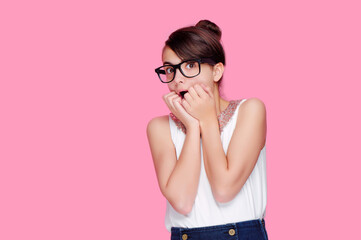 Pretty girl wearing glases expressing amazement isolated on pink background