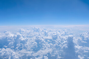 Fototapeta na wymiar Blue sky and many white cumulus clouds. Aerial view from airplane window. Background with copy space.