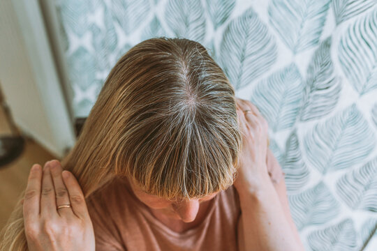 Close-up Of Woman's Head With Loose Blond Hair Growing Back Gray Hair Roots