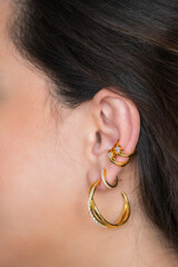 Woman ear with mulriple piercings wearing beautiful earrings with zirconia.  Beautiful valentine's...