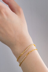 Beautuful woman wrist wearing bracelets set against white. Beautiful valentine's gifts.