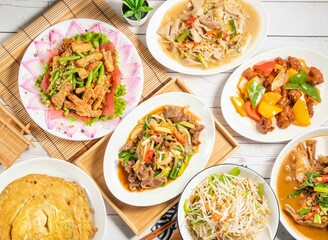 Fried Onion Egg, Four Seasons Fat Sausage, Sweet and sour pork ribs, Fried large intestine, Fresh fried vegetables, served in dish isolated on wooden tray and napkin top view of assorted taiwan food