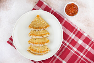 Christmas and New year tree shaped pancakes or crepes with red caviar decorations on light colored background. Holiday homemade food. Flat lay top view. Christmas food for children and kids.
