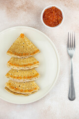 Christmas and New year tree shaped pancakes or crepes with red caviar decorations on light colored background. Holiday homemade food. Flat lay top view. Christmas food for children and kids.