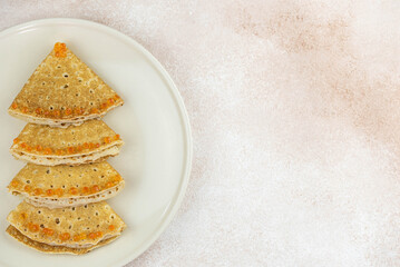 Christmas and New year tree shaped pancakes or crepes with red caviar decorations on light colored background. Holiday homemade food. Flat lay top view. Christmas food for children and kids.