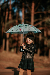 Dziewczynka z parasolem na drodze 