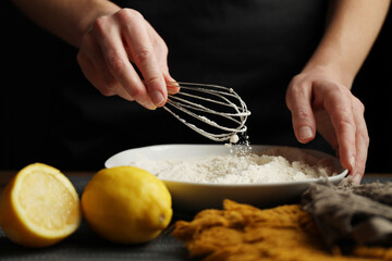 Cooking homemade cakes, the hands of the cook stir the flour.