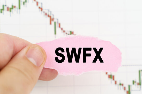 Against the background of the quote chart, a man holds a sign with the inscription - SWFX