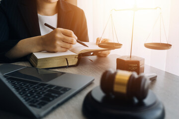 law books and scales of justice on desk in library of law firm. jurisprudence legal education concept.