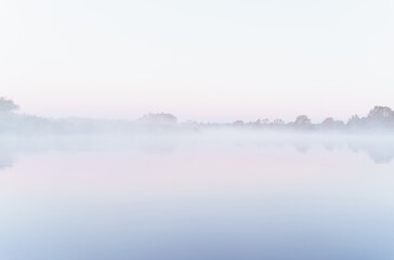 Autumn on the lake in the morning mist