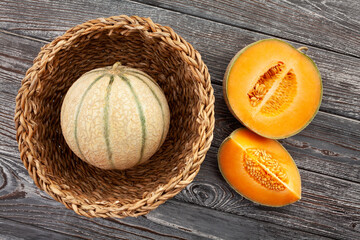 sliced cantaloupe melon on wood background top view