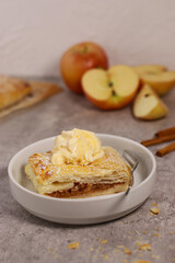 piece of an apple strudel roll with cinnamon and ice cream on top