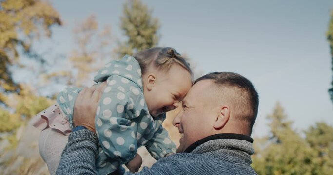 Happy father playing with his little daughter in the park, have a good time together