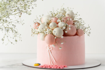 Wedding cake with pink cream cheese frosting decorated with chocolate spheres and field  gypsophila...
