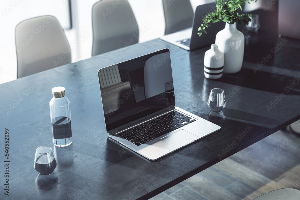 Poster perspective view on modern laptop on dark concrete effect table with glass of water and light vases 